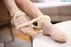 A woman's feet tied up with a pair of ballet shoes.