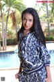 A woman standing in front of a swimming pool.