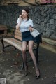 A woman sitting on a bench smoking a cigarette.