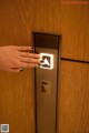 A woman's hand is pressing a button on an elevator.