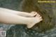 A woman's bare feet in the water of a river.