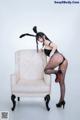 A woman in a bunny costume sitting on a chair.