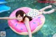 A woman laying on an inflatable donut floating in a pool.