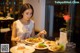 A woman sitting at a table with plates of food.