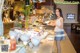 A woman standing in front of a buffet holding a plate of food.