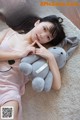 A woman laying on the floor with a stuffed animal.