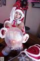 A woman dressed as a santa claus holding a crystal ball.