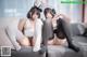 Two women in bunny ears are sitting on a couch.