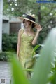 A woman in a yellow dress and a straw hat.