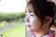 A young woman looking out a window at the grass.