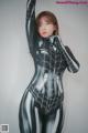 A woman in a black and silver spider suit posing for a picture.