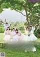 A group of young women posing for a picture in a park.