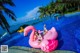 A woman laying on an inflatable flamingo in a swimming pool.