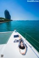 A woman laying on the deck of a boat in the ocean.