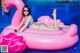 A woman in a blue bikini laying on an inflatable flamingo.