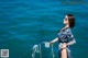 A woman in a blue and white dress standing on a boat.