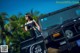 A woman sitting in the driver's seat of a black jeep.