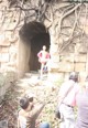 A group of people taking pictures of a woman in a tunnel.