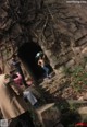 A group of people standing in front of a stone wall.