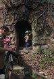 A man taking a picture of a naked woman in a tunnel.