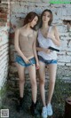 Two young women standing next to each other holding guns.