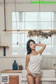 A woman standing in a kitchen next to a sink.