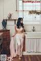 A woman standing in a bathroom next to a sink.