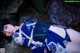 A woman in a blue and white kimono laying on a rock.