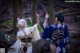 Two women dressed in kimono standing in the woods.