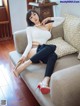 A woman sitting on a couch wearing high heels.