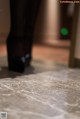 A close up of a person standing on a tiled floor.