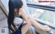 A young girl sitting on a window sill looking out the window.