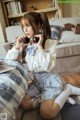 A woman sitting on the floor listening to music with headphones.