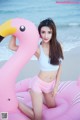 A woman in a white top and pink shorts posing with a pink flamingo.