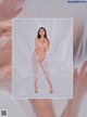 A woman in a white lingerie is posing in a plastic bag.