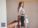 A woman standing on a wooden staircase holding a white bag.