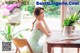 a woman sitting at a table with a potted plant