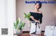 A woman standing next to a table holding a plant.