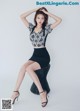 A woman sitting on top of a wicker chair with her legs crossed.