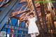 A woman in a white dress standing on a bridge.