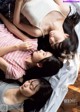 A group of young women laying on top of a bed.